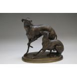 AFTER MENE - A CAST BRONZE FIGURE OF TWO GREYHOUNDS, raised on an oval base, W 16 cm, H 15 cm