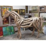 A LIFE SIZE DECORATIVE DRIFT WOOD FIGURE OF A STANDING HORSE, approximate H 180 cm, L 254 cm