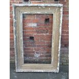 A LARGE ANTIQUE GILTWOOD PICTURE FRAME WITH CARVED DECORATION THROUGHOUT, rebate 58 x 104 cm A/F
