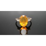 A HALLMARKED 9 CARAT YELLOW GOLD FIRE OPAL RING, with a large oval claw set fire opal measuring