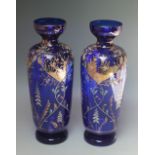A PAIR OF LATE 19TH CENTURY BLUE GLASS VASES, decorated throughout with gilt and floral painted