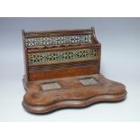 AN EARLY 20TH CENTURY OAK DESK STAND, the letter divisions having plated pierced grill, minus ink