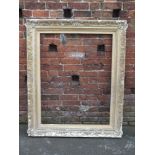 A LARGE ANTIQUE GILTWOOD PICTURE FRAME, floral moulded detail throughout, rebate 111 x 85 cm