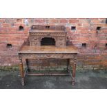 A VICTORIAN CARVED OAK DESK, having an upper section with five drawers with central recess, single