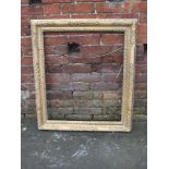 AN ANTIQUE CARVED GILTWOOD PICTURE FRAME, with moulded foliate detail, rebate 74 x 62 cm