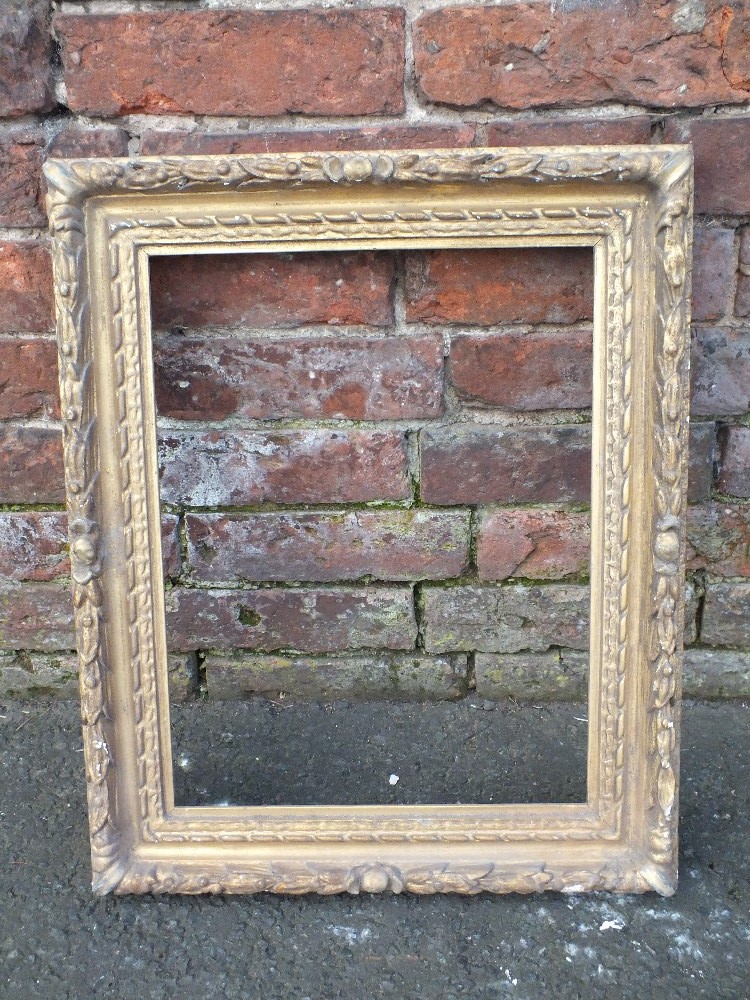 AN ANTIQUE CARVED GILTWOOD PICTURE FRAME, with moulded fruit decoration, rebate 42 x 32 cm