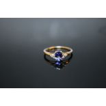 A HALLMARKED 9K GOLD TANZANITE RING, having an oval claw set tanzanite measuring approx 6 mm x 4 mm,