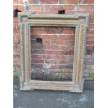 A LARGE HEAVY ANTIQUE GILTWOOD PICTURE FRAME, moulded decoration throughout with a circular floral