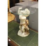 A SMALL DECORATIVE GLASS TOPPED TABLE