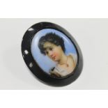 A BOXED VICTORIAN EBONISED ENAMEL PAINTED CAMEO BROOCH