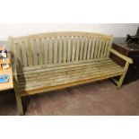 A LARGE WOODEN GARDEN BENCH