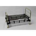 A VICTORIAN STYLE CAST IRON SALESMAN SAMPLE DOLLS BED, with wire springs and brass ends
