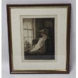 A FRAMED AND GLAZED ENGRAVING, depicting a lady reading by a window signed in pencil to the lower r