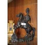 A BRONZE EFFECT FIGURE OF A MAN ON HORSEBACK