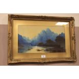 A GILT FRAMED AND GLAZED OIL OF A MOUNTAINOUS LAKE SCENE