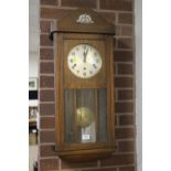 AN OAK CASED WALLCLOCK