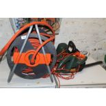 A BLACK AND DECKER HEDGE CUTTER, CHAIN SAW, AND A HEAVY DUTY HOSE AND REEL