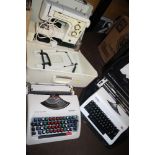 A CASED FRISTER SEWING MACHINE TOGETHER WITH TWO TYPEWRITERS