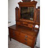 AN OAK DRESSING TABLE WITH CARVED DETAIL AND TILTING MIRROR