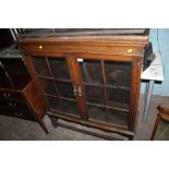 AN OAK GLASS PANELLED BOOKCASE