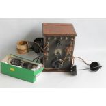 AN UNUSUAL EARLY 20TH CENTURY RADIO SET, with wood case and bakelite front plate with headphones,