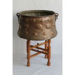 A LARGE TURKISH COPPER CAULDRON POT, hammered decoration, with iron swing handle fittings on