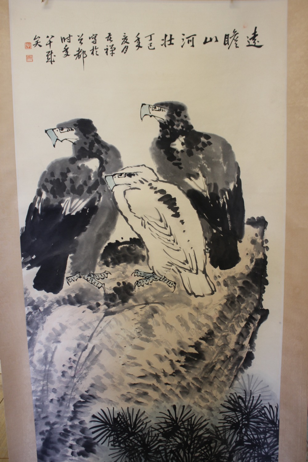 A 20TH CENTURY ORIENTAL SCROLL DEPICTING BIRDS OF PREY ON A ROCKY OUTCROP, character marks to top