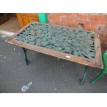 A CAST GARDEN TABLE WITH A WOODEN BORDER