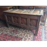 A LATE 17TH CENTURY OAK COFFER WITH FOUR CARVED PANELS TO THE FRONT BELOW A PLAIN FOUR PANELLED RISI