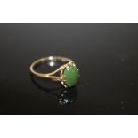 A LADIES 9CT GOLD DRESS RING SET WITH A POLISHED GREEN STONE