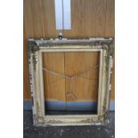 A 19 TH CENTURY DECORATIVE GILT FRAME WITH SWEPT CORNERS 77 X 64 CM