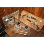 A BRASS FRAMED MIRROR, TWIN INKWELL DESK STAND AND A DECORATIVE BRASS PISTOL DISPLAY (3)