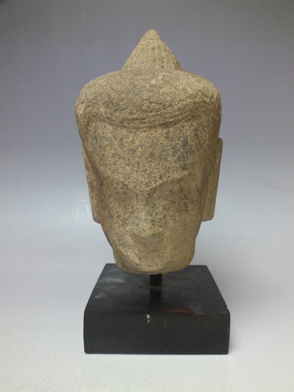 A CIRCA 13TH CENTURY CAMBODIAN SANDSTONE HEAD, Khumer period, H 19 cm, overall H 25 cm inc base
