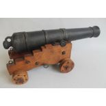 A CAST IRON MODEL, COLONIAL STYLE 12 POUND CANNON, on wooden carriage, length of cannon 39.5 cm