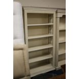 A MODERN PAINTED BOOKCASE WITH DECORATIVE SPINDLE EFFECT TO THE SIDE PANELS