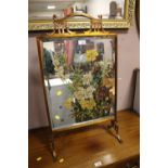 A BRASS MIRRORED FIRESCREEN WITH FLORAL PAINTED DETAIL