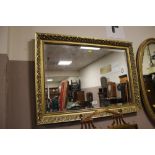 A MODERN GILT FRAMED WALL MIRROR