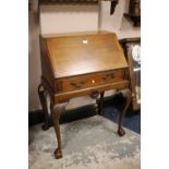 A SMALL MAHOGANY LADIES BUREAU WITH CARVED DETAIL ON CABRIOLE SUPPORTS