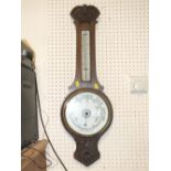 A CARVED OAK ANEROID BAROMETER