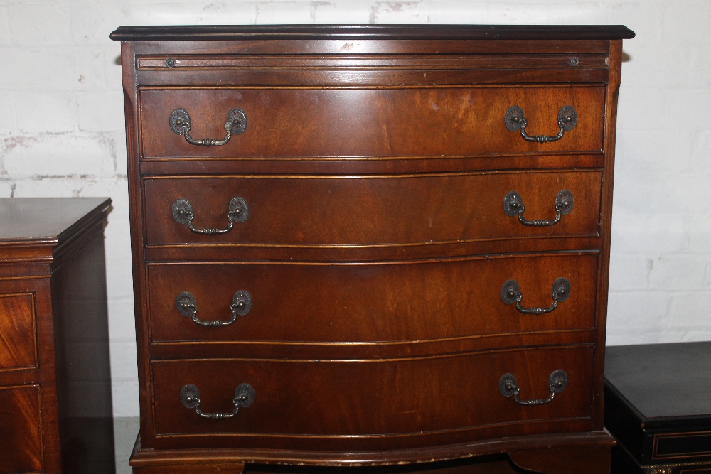 A SERPENTINE FRONTED CHEST OF DRAWERS WITH BRUSHING SLIDE