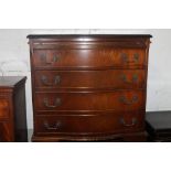 A SERPENTINE FRONTED CHEST OF DRAWERS WITH BRUSHING SLIDE