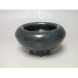 A BLUE CERAMIC BOWL UPON THREE PEG FEET, with fold over rim, Dia 11.75 cm