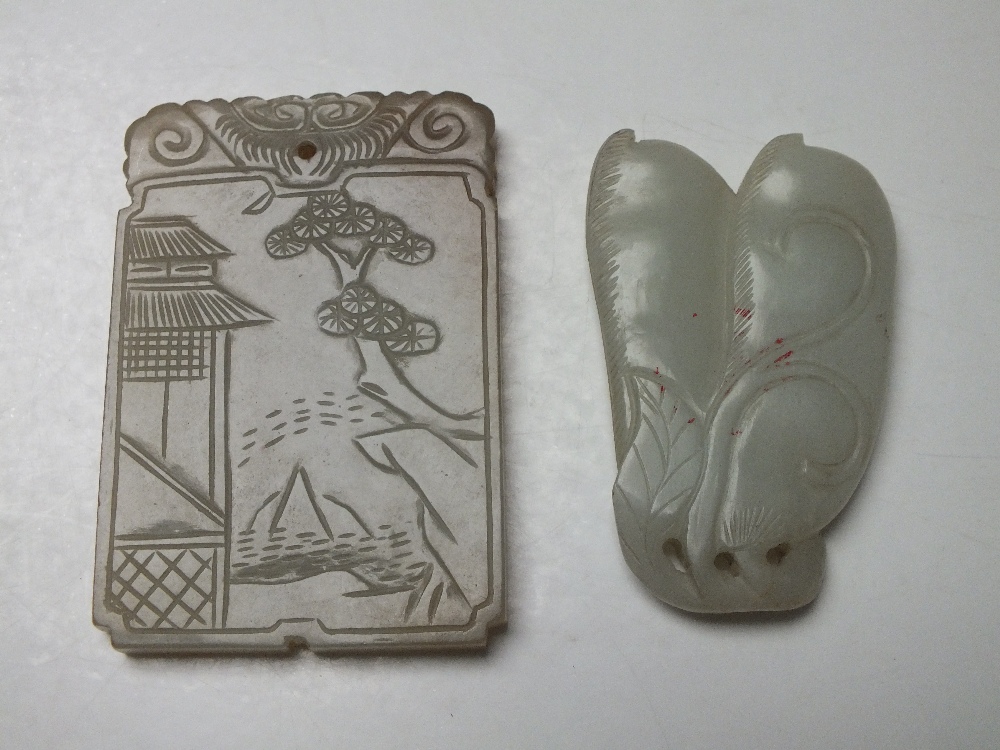 A CHINESE CELADON JADE PENDANT, finely carved in shallow relief to one side with a landscape