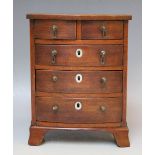 A SMALL GEORGIAN MAHOGANY MINIATURE BOW FRONTED CHEST, with five drawers, raised on shaped feet, H