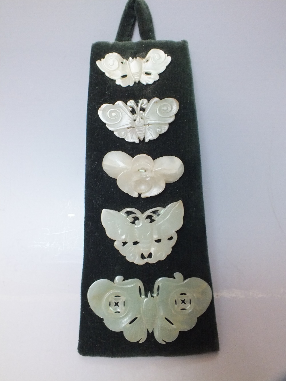 A COLLECTION OF FIVE CHINESE CELADON JADE CARVED INSECT / MOTH PLAQUES, in varying sizes, finely