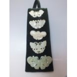 A COLLECTION OF FIVE CHINESE CELADON JADE CARVED INSECT / MOTH PLAQUES, in varying sizes, finely