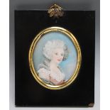 A NINETEENTH CENTURY OVAL PORTRAIT MINIATURE OF A LADY IN A PINK AND WHITE DRESS, in a black frame