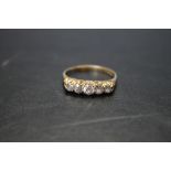 AN HALLMARKED 18 CARAT GOLD FIVE STONE DIAMOND RING, the central diamond being approx 0.25 ct,