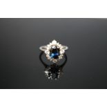 A SAPPHIRE AND DIAMOND RING, set in white metal stamped 18K, the central sapphire measuring approx