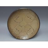 A 20TH CENTURY STUDIO POTTERY SHALLOW BOWL, the incised decoration depicting four juvenile faces,